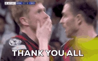 Sports gif. Closeup of Kevin De Bruyne of Manchester City kissing his fingers and raising his hands to the sky with dozens of fans in the stadium in the background, saying, "Thank you all."