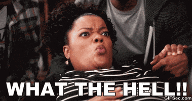 TV gif. Yvette Nicole Brown as Shirley Bennett in Community leans up and shouts while holding onto her stomach, two people in the background behind her with one holding her hand. Text reads “What the hell!!”