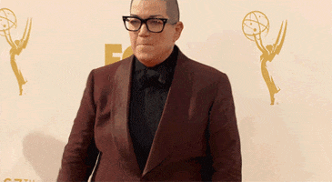 Celebrity gif. Lea Delaria from Orange Is The New Black triumphantly pumps her fist towards the ground and yells in celebration at the Emmys' red carpet.