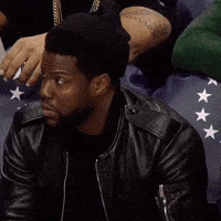 Celebrity gif. Kevin Hart sits at a basketball game, leaning forward in his seat. He looks around and nods, pretty impressed by what he just saw. 