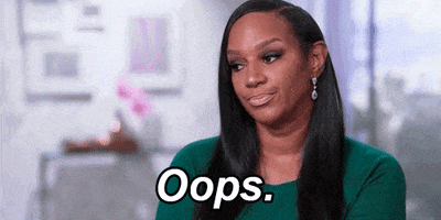 Reality TV gif. Jackie Christie from Basketball Wives appears vaguely apologetic, shrugging and barely opening her mouth as she says "oops," which appears as text.