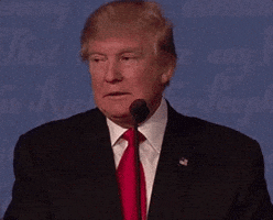 Politics gif. Donald Trump behind a mic, appearing to grind his teeth and fiddle with papers in front of him, then looks forward at us resolutely.