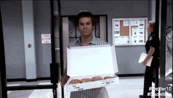 Michael C Hall as Dexter Morgan in Dexter swaggers into the office with a slight smirk. He knows he's the hero of the day, because he's brought a gift for his colleagues: an open box of a dozen perfectly-glazed donuts.