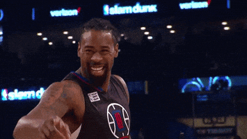 Sports gif. Slow-motion footage of a very cheerful DeAndre Jordan, pointing to us as he walks by.