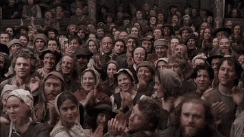 Movie gif. From Shakespeare in Love: A sea of cheerful faces applaud and celebrate. 