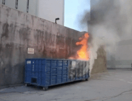 Video gif. A blue dumpster, the contents of which are in flames. A literal dumpster fire.