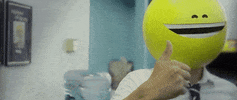 Video gif. A man is wearing a yellow smiling emoji on his head and he gives us a thumbs up.