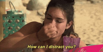 Reality TV gif. Ashley on Bachelor in Paradise lays down on a beach chair. She holds her nails up to her lips to blow on them, then looks down at them, and blows on them again. She says, ‘How can I distract you?”