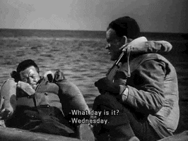 Movie gif. Two men are wearing life vests and sitting in a raft, floating on the sea, in a black and white film. One man asks, "What day is it?" and the other responds with, "Wednesday."