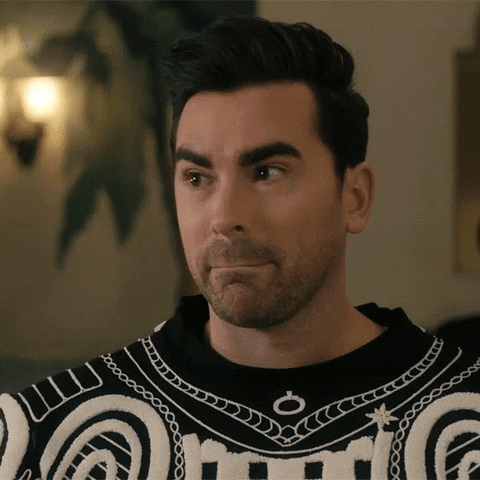 Schitt's Creek gif. Dan Levy as David wearing a complicated black-and-white sweater speaks to us with a disdainful eye roll. Text, "'K."