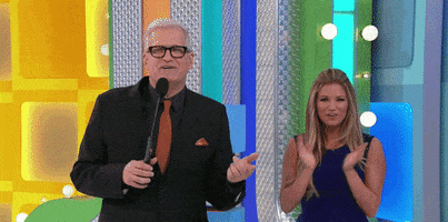 TV gif. Drew Carey is hosting The Price is Right with Rachel Reynolds, a model for the show. Rachel is clapping when she suddenly stumbles. She catches herself and ends up laughing with Drew, who notices.