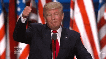 Political gif. Donald Trumps stands up at a podium and smiles widely as he gives a big thumbs up.