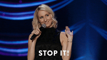 TV gif. Nikki from Nikki Glaser's stand-up playfully waves us away, and says with a smile: Text, "Stop it!"