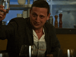 TV gif. Tim Robinson from I Think You Should Leave with Tim Robinson. He's drunk and has his glass in the air, raising a toast while wetly saying, "To friends!"
