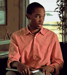 Video gif. Young man turns to look over his shoulder and then back at us with a questioning look. 
