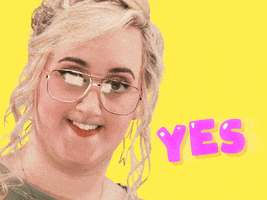 Video gif. Influencer Brittany Broski, her top lip tucked under itself, looks nerdily and intensely into the camera next to the word "yes."