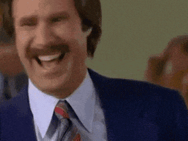 Movie gif. Actor Will Ferrell as Ron Burgundy in Anchorman laughs and awkwardly announces. "We are laughing."