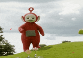 TV gif. Po the Red Teletubby from Teletubbies stands on top of a lush green hillside with trees and flowers. She puts her finger to her lips and then falls down on the hill, laying on her back, and red hearts come out. Text, "Falling for you."