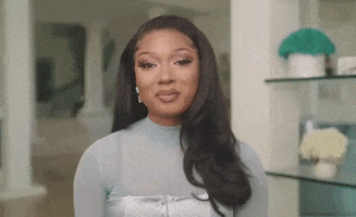 Celebrity gif. Megan Thee Stallion laughs as she tosses her hands over her shoulders. She points a bedazzled finger to the air with a wide smile. Text, "You know!"