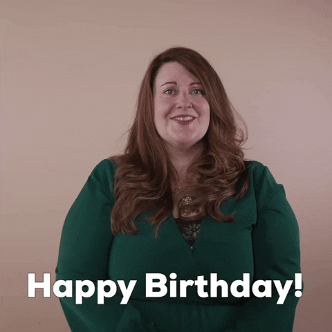 Reaction gif. A non-apparently Disabled white woman with with anxiety and depression and long red hair pumps the air, palms to us, fingers splayed, and says, "Happy birthday!"