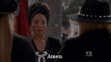 TV gif. Angela Bassett as Marie Laveau on American Horror Story Coven wears a black headdress and looks at two women in front of her. She shrugs her shoulders as she says, “Amen.”