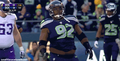Sports gif. Brandon Mebrane from the Seattle Seahawks is doing a celebratory body roll on the field.