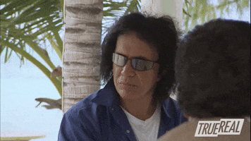Reality TV gif. Gene Simmons sticks his tongue out in casual disgust, turning his head away.