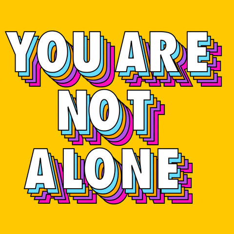 Digital art gif. In white, all-caps text with rainbow shadows, bouncing letters spell out "You are not alone," against a yellow background.