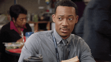 TV gif. Tyler James Williams as Gregory on Abbott Elementary sits in the teacher’s lounge with a sandwich in his hand. He looks at someone like he just heard the craziest thing ever and looks at us with concern and confusion.