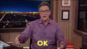 TV show gif. Stephen Colbert stands on the set of The Late Show and stacks his arms in front of his chest playfully, tilting his head with a smile and saying, "Ok."
