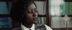 Movie gif. Lupita Nyong'o as Khadijah on The Three Five Five blinks as she glances to the side looking annoyed. 