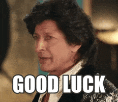 Celebrity gif. Jeff Goldblum with dark, shaggy hair, wearing a flashy jacket, whips his head to look at us. Text, "Good luck."