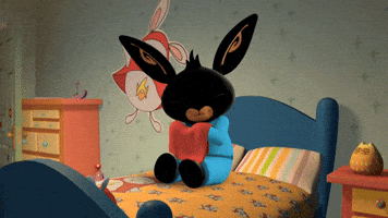Cartoon gif. Bing Bunny sits on his bed rubbing a red towel on his chin for comfort, closing and opening his eyes with a pleasant expression.