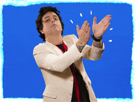 Celebrity gif. Billie Joe Armstrong from Green Day is leaning to one side and looking down at us with pride as he claps for us.