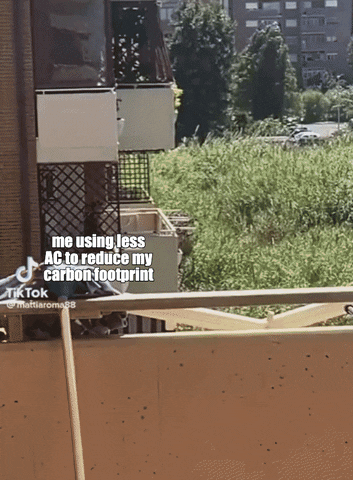Video gif. Woman labeled “me using less AC to reduce my carbon footprint” steps out of her apartment and throws a bucket of water over the balcony towards a massive wildfire headed toward her building that is labeled “the 100 corporations responsible for 71% of carbon emissions.”