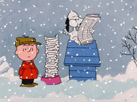 Peanuts gif. Charlie Brown stands bewildered next to Snoopy's doghouse as it snows. Snoopy sits on top of the doghouse reading a newspaper and quickly munching bones from a tower of them in his bowl.