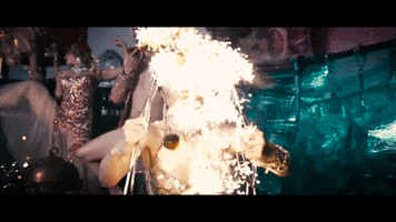 Ad gif. Company XIV's advertisement of Baroque Burlesque features a woman separating flaming wires bent in the shape of flowers in front of her face.