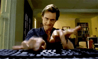 Movie gif. Jim Carrey as Bruce in Bruce Almighty furrows his brow and bites his lip as he pounds wildly on a computer keyboard in the foreground.