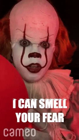 Movie gif. Pennywise the Clown from It glares ahead menacingly as it grins. Text, " I can smell your fear."