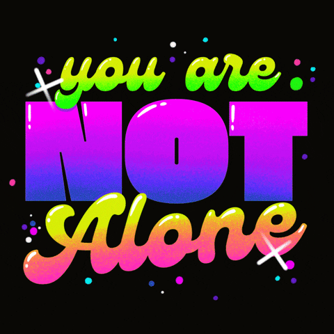 Digital art gif. In groovy, rainbow-colored and pink letters, text reads, "You are not alone," against a black background.