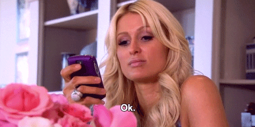 Celebrity gif. Paris Hilton is staring at her purple cellphone and says, "OK," in response without ever taking her eyes off her phone.