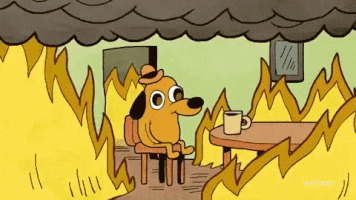 Cartoon gif. This is Fine dog in a bowler hat sits at a table with a mug as flames blaze all around him and smoke drifts above his head. In the next frame, a closeup of the dog shows his dazed eyes as he looks in the coffee cup and says, "This is fine."