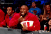 TV gif. A captivated WWE fan excitedly chomps popcorn, making a mess.