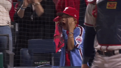 Sports gif. Phillies" player Nick Castellanos" son Liam stands up in the stands, screaming into a towel and holding his hands to his temples like he's totally amazed and it's blowing his mind. 