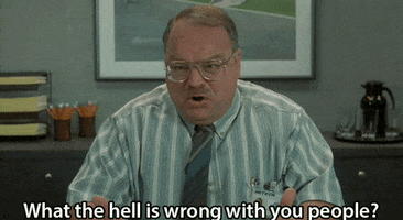 Movie gif. Richard Riehle as Tom in Office Space yells angrily, glancing around and shaking his hands, "What the hell is wrong with you people?" which appears as text.