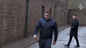TV gif. Jamie Lomas as Warren and Maxim Baldry as Liam face off in an argument set in an alleyway.