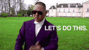 TV gif. Eddie Huang from Huang's World stands on a grass lawn in front of a mansion, wearing a purple suit and sunglasses. Text, "Let's do this."