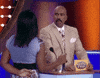 Reality TV gif. Steve Harvey on Family Feud looks at a girl who is giggling. He has a stunned expression on his face. He blinks and shakes his head, furrowing his brows at her to figure out what she had just said to him. 