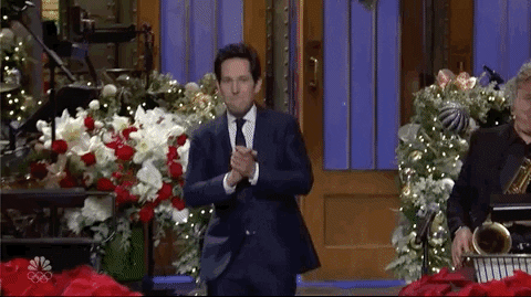 SNL gif. Paul Rudd enters, descending the steps with enthusiasm and a celebratory fist pump, proclaiming "wow!"
