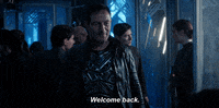 TV gif. Jason Isaacs as Gabriel Lorca in Star Trek Discovery. He stands in the ship and stares someone down with a small smile on his face as he says, "Welcome back."